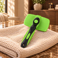 Cargar la imagen en la vista de la galería, Green and black self-cleaning slicker brush with round cleaning button on a towel over brown marble.
