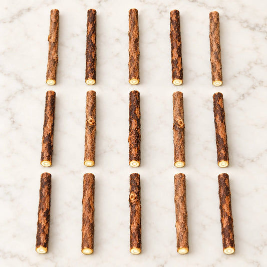 15 natural matatabi cat chew sticks arranged on a pale marble surface