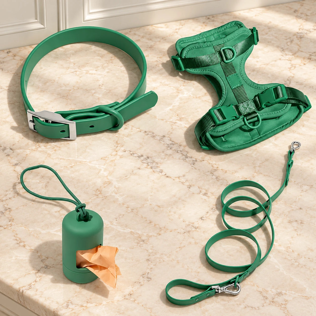 Green dog harness, collar, lead and bag holder arranged on beige marble