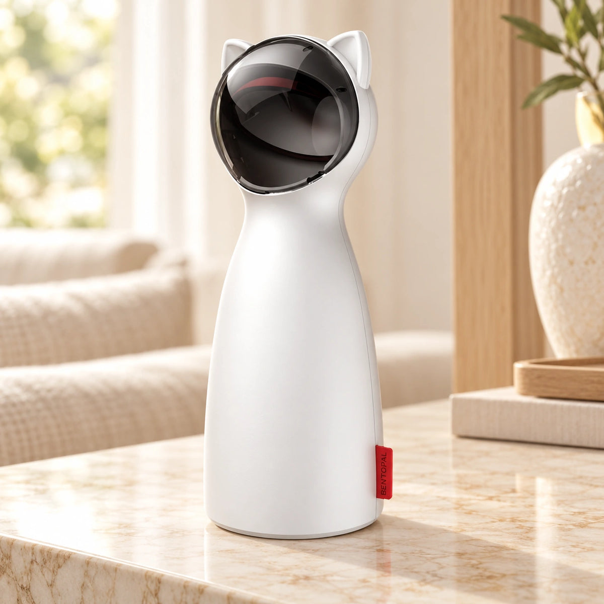 White automatic cat laser toy with black cat-ear head and red side tab on pale beige marble